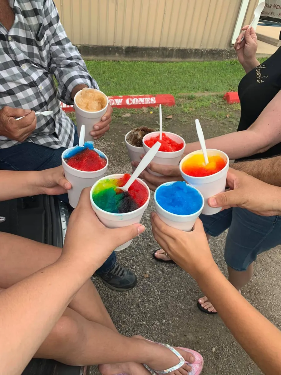 Friends raising six rainbow snow cones