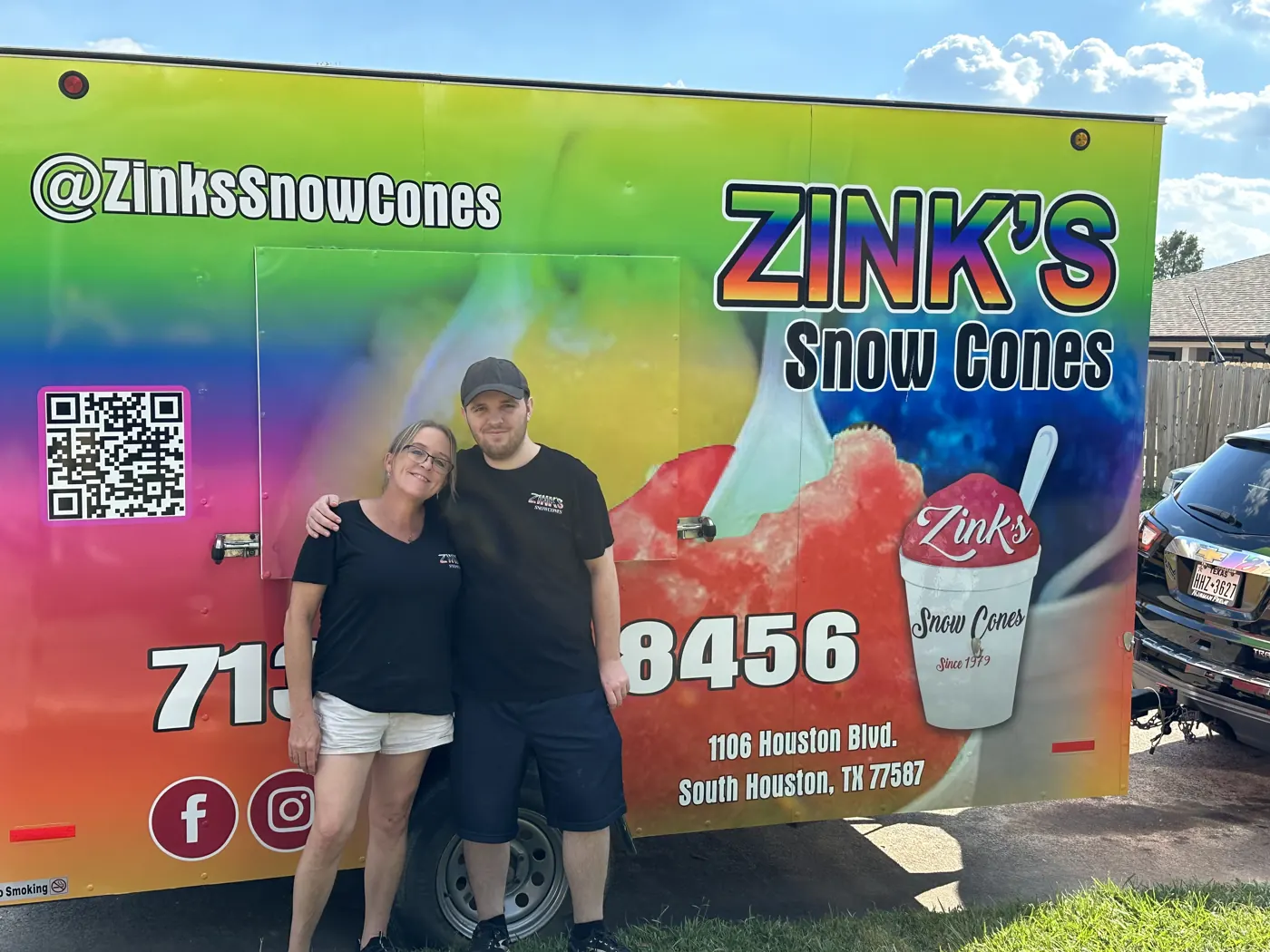 The Zink's family standing in front of the trailer